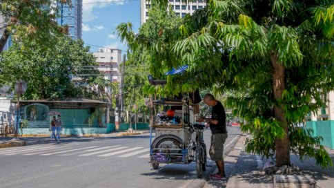 بائع متجول يتقي من الحر في ظل شجرة في مانيلا في 28 نيسان (أبريل) 2024 