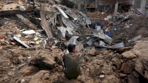 طفل فلسطيني قرب أنقاض مبنى سكني دمرته غارة إسرائيلية في الزوايدة وسط قطاع غزة في 11 أيار (مايو) 2024 