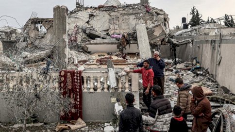 أشخاص يتفقدون الأضرار التي لحقت بمبنى أصيب خلال الليل خلال قصف إسرائيلي في رفح بجنوب قطاع غزة 26 آذار (مارس) 2024