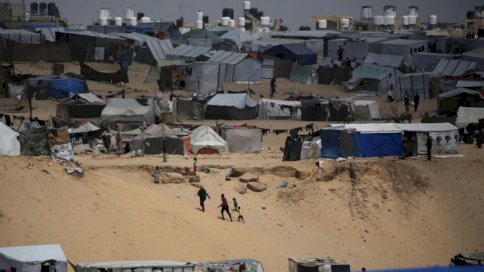 فلسطينيون يسيرون في مخيم للنازحين في رفح في أقصى جنوب قطاع غزة قرب الحدود مع مصر في 28 نيسان (أبريل) 2024 