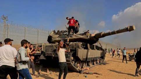 فلسطينيون يحتفلون بالاستيلاء على دبابة إسرائيلية بعد اقتحام الجدار الحدودي