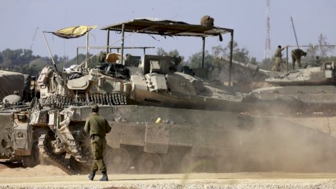 جندي إسرائيلي يقف خلف دبابة بينما تجمعت القوات في موقع قرب الحدود مع قطاع غزة في جنوب إسرائيل 30 نيسان (أبريل) 2024