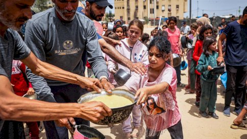 نازحون فلسطينيون يصطفون لاستلام الطعام في رفح، جنوب قطاع غزة، فلسطين، في 19 مايو 2024