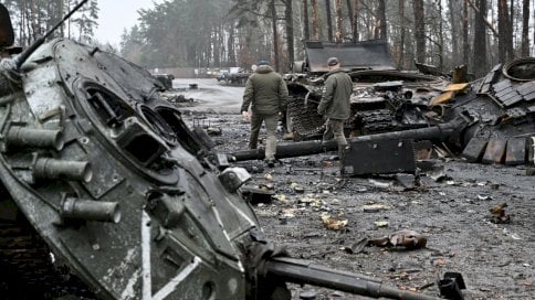دبابات روسية محترقة بقربها جنود أوكرانيون يتفحصون بقاياها 