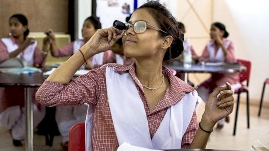 طالبة تستخدم مساعدات الرؤية والنظارات لمحاكاة ضعف البصر أثناء مشاركتها في برنامج تدريب موظفي طب العيون المعتمد في نيودلهي
